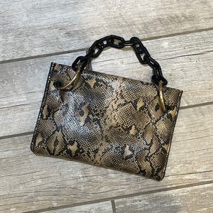 Snakeskin look clutch with black chain look handle.